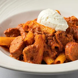 a bowl of pasta with meat and cheese