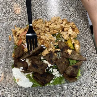 a person holding a fork over a salad