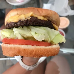 a hamburger with lettuce, tomato, and cheese