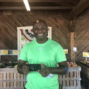 a man in a green shirt holding a camera
