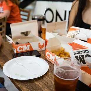 people sitting at a table with drinks and food