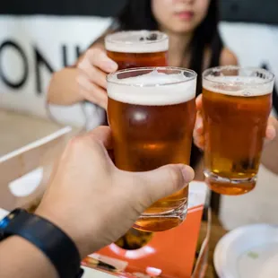 a group of people toasting beer glasses