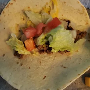 a taco with lettuce and tomatoes