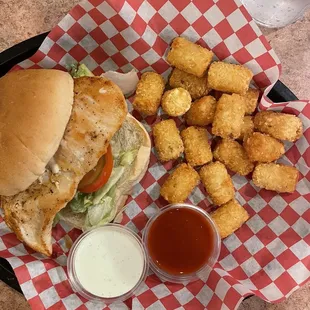 Grilled chick sandwich with tater tots and a side of ranch and buffalo sauce