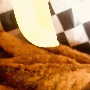 fried fish and fries with a lemon wedge