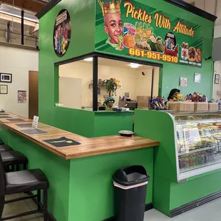 a green counter with black chairs