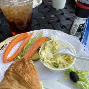 Chicken salad sandwich on a croissant with the potato salad, carrots and celery on the side and amazing sweet tea