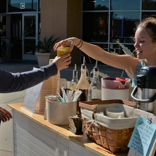 a woman handing a sandwich to another woman