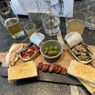 &quot;Tin Fish&quot; board with tuna, octopus, anchovy stuffed olives, smoked clans, chorizo, butter, and crostini
