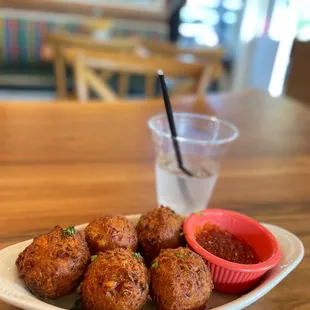 a plate of fried meatballs with dipping sauce