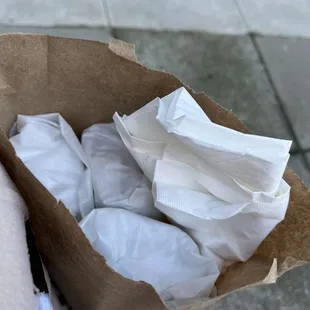 a person holding a paper bag full of tissues