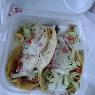 two tacos in a styrofoam container