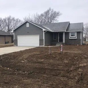 the front of a house with a driveway and garage