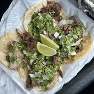 a plate of tacos with a lime wedge