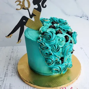 a birthday cake with a woman sitting on top of it