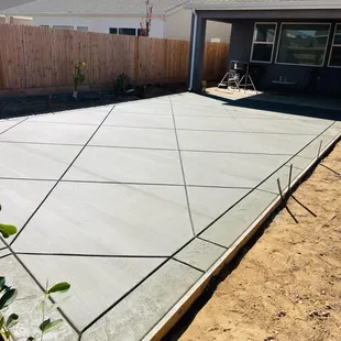 Diamond shaped concrete joints etched into the design with a stamped band surrounding the large pad