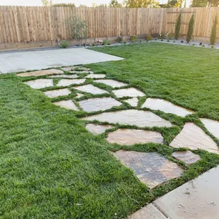 Wide Flagstone walkway connecting a new concrete pad with natural Bermuda sod in between