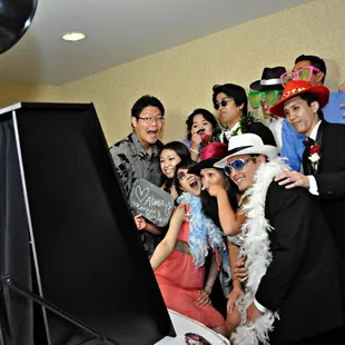 In front of the photo booth, with props on.