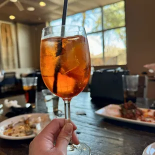 a person holding a glass of iced tea