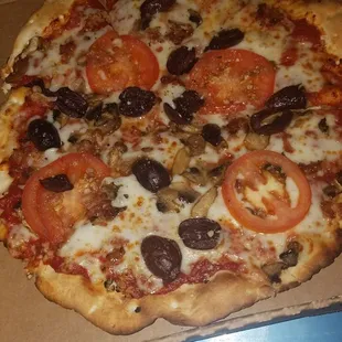 Crispy thin, spicy marinara? Mozzarella, bacon, minced garlic, kalamata olives, mushrooms, Roma tomatoes, fresh basil, magic dust