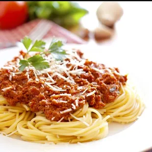 a plate of spaghetti with sauce and parmesan cheese