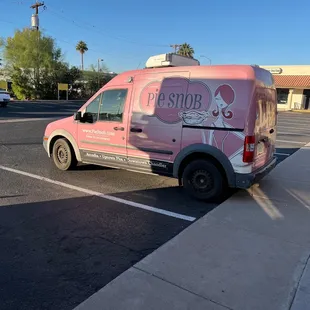 a pink van parked in a parking lot