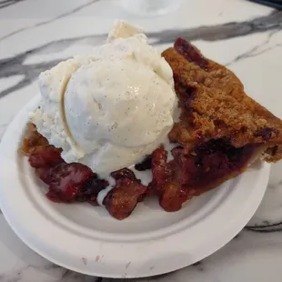 A warm slice of razzleberry a la mode with vanilla ice cream  heavenly