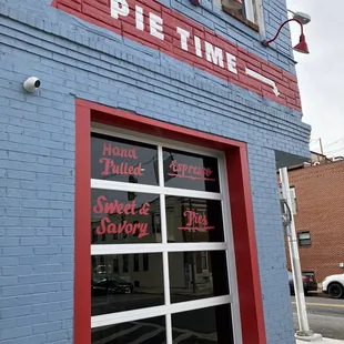 a blue brick building with red trim