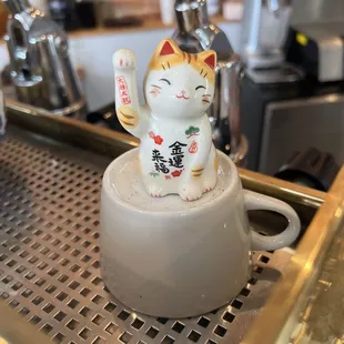 a cat figurine on a coffee cup