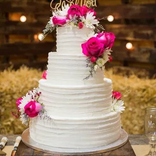 a white wedding cake with pink flowers