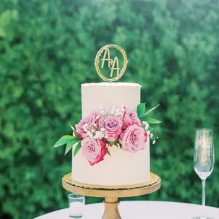 a white wedding cake with pink flowers