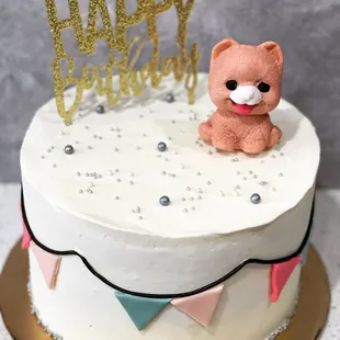 a teddy bear on top of a birthday cake