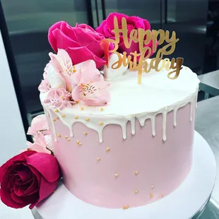 a pink and white birthday cake