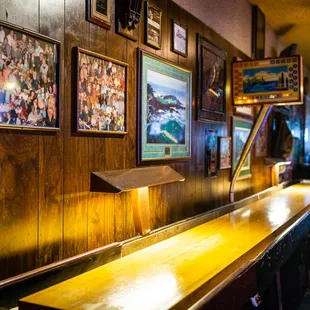a long wooden bar with pictures on the wall