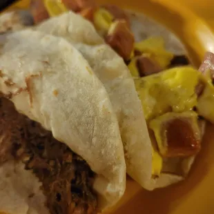 Barbacoa taco and country sausage n egg taco on fluffy flour tortillas