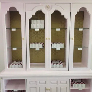 a white china cabinet with glass doors