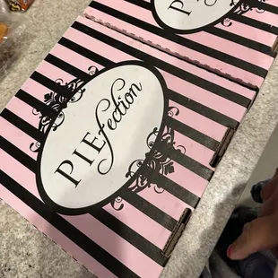 a pink and black striped pizza box