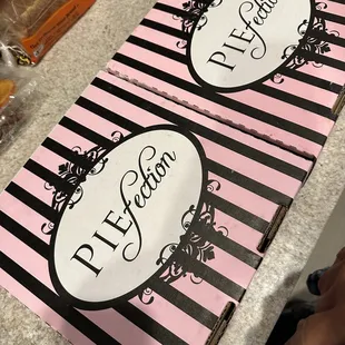 a pink and black striped pizza box