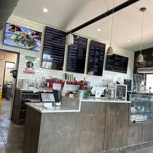 a restaurant counter with menus on the wall