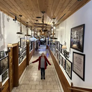 a woman walking down a long hallway
