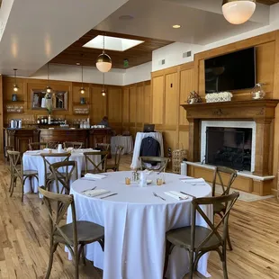 a dining room with a fireplace and wood paneled walls