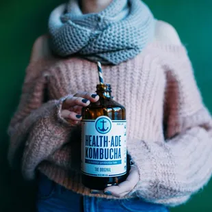 a woman holding a bottle of beer