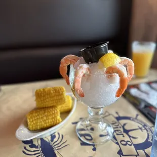 a shrimp cocktail and corn on the cob