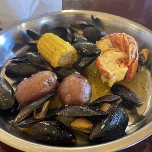 Mussels, lobster tail, potatoes and corn in garlic butter sauce.