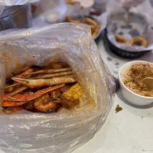 Low country boil  88 special medium sauce and white rice Fried calamari hiding in the back with Cajun fries