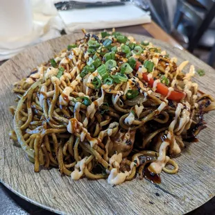 a plate of noodles on a wooden plate