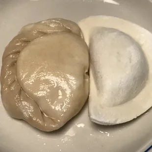 a plate of pierogi and a bowl of yogurt