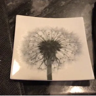 a plate with a dandelion on it