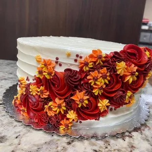 a cake decorated with red and yellow flowers