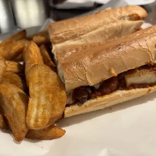 Chicken parm sandwich with potato wedges.